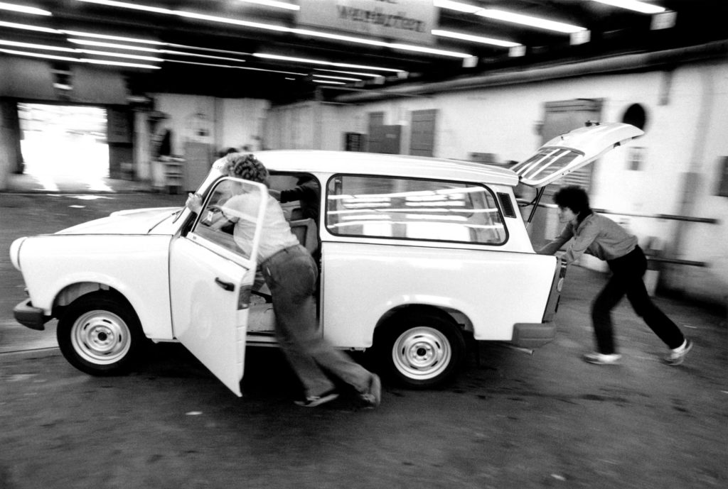 Workers push a complete Trabant out of final assembly, 1991